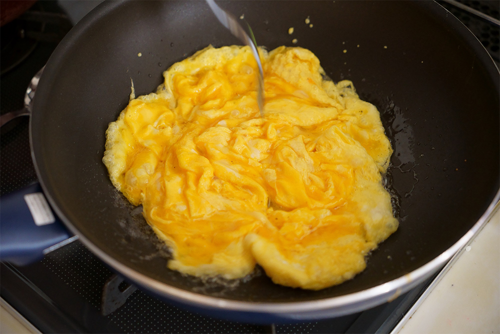 卵焼きは「ふわトロ」を目指す。コンロ上で安定し、焦げ付きにくいフライパンを使う。火にかけたフライパンの中で、空気を抱え込ませるようにフォークで数カ所を小刻みに混ぜ、火入れは7～8割程度にとどめる。これがおいしさの秘訣の一つ！