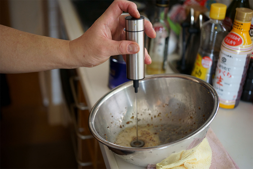 (F)キャロット・ラペのドレッシングの撹拌はミルク泡立て器が役立つ。濡れタオルにボウルを傾けて置くと、混ぜやすい。