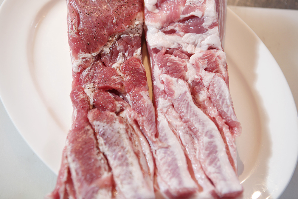 バラ肉の表面に塩とコショウを振り、ラップで包んで冷蔵庫に３日間置く。左が３日後の肉。色が深くなる。
