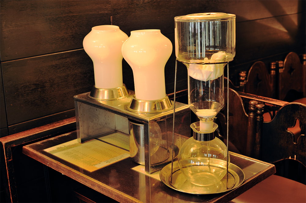 水出しコーヒーの機器。左の白いガラスが最新で、右が吹きガラスで造られた一代前のもの。豆は1/4にカットしてシルバースキンを取り除いてから挽き、水でゆっくり落とすため、驚くほどクリアな味わい。