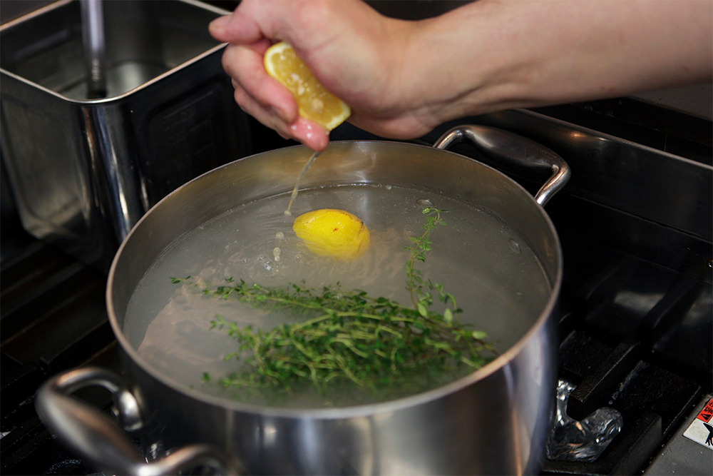 鍋に水を入れて温める。レモンは果汁を搾ってから皮ごと入れ、塩、タイム、オリーブ油（大さじ１）を加える。