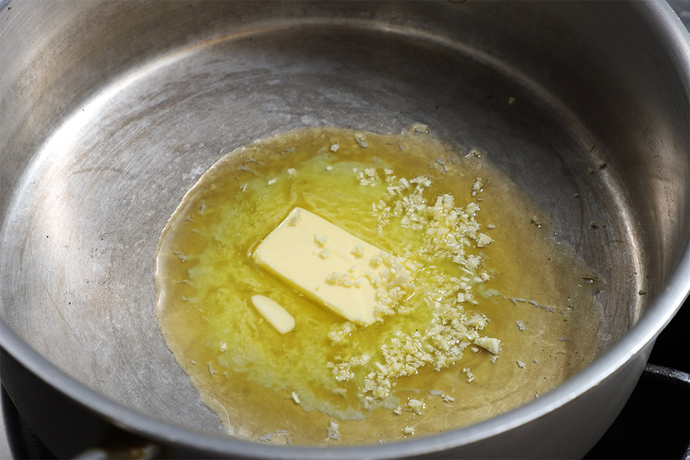 無塩バターとニンニクを鍋に入れて弱火にかけ、バターを溶かす。ニンニクに色を付けないように注意する。 【４】最初に塩をしてから炒める