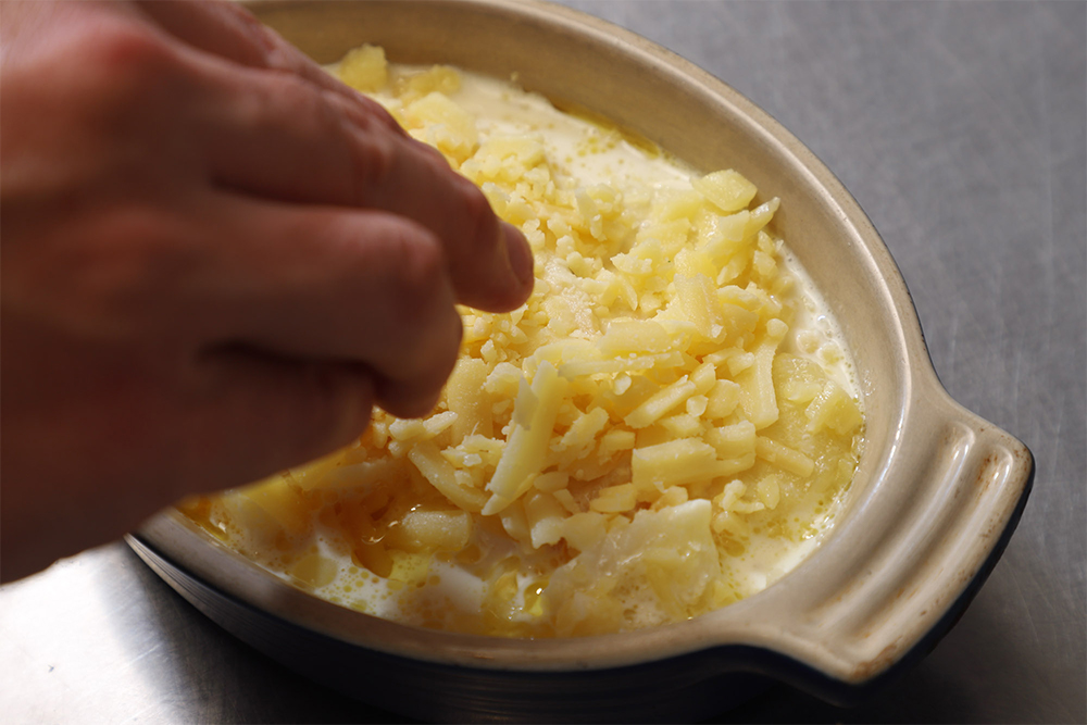 電子レンジで１分温め、ラクレットチーズをかける。180℃のオーブンで約10分、チーズに焼き色が付くまで焼く。 【完成】