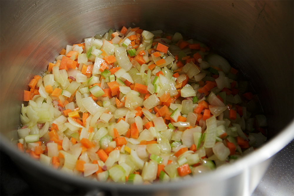 ニンジン、ジャガイモは皮を剥き、セロリは筋をとり、粗いさいの目に切り、鍋に加え、透き通るまで炒める。