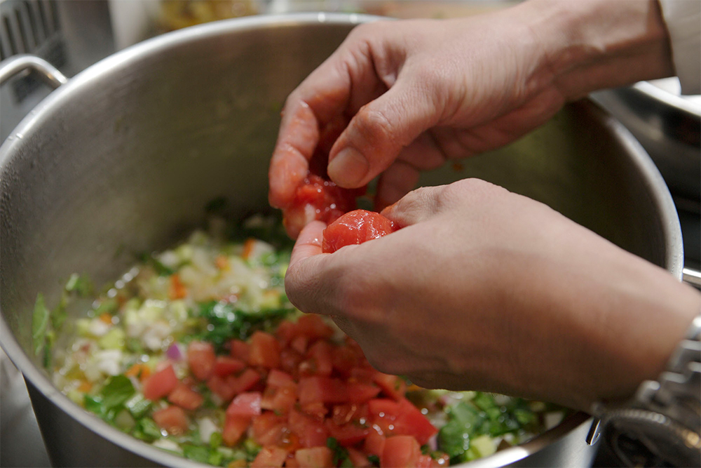 さいの目にカットした生トマトと、ホールトマトを手でひと口大にちぎりながら入れ、沸いたら５分程煮る。