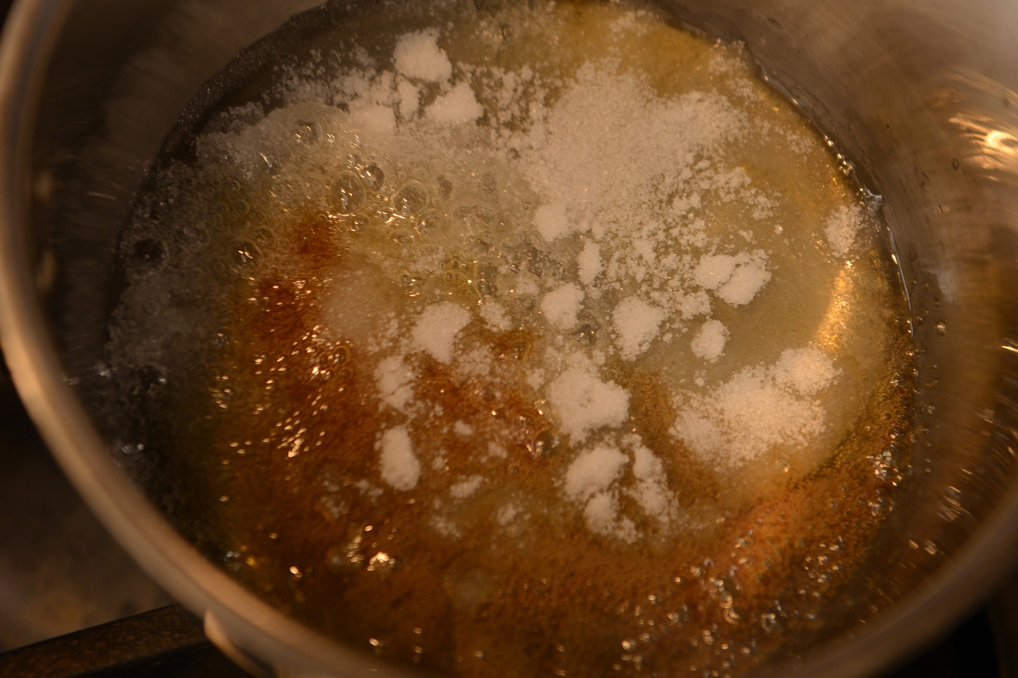 【５】カラメルを作る。鍋の内側を水で濡らし、グラニュー糖を75g入れて強めの中火にかける。スプーンは使わず、鍋を傾けたり、揺すって全体に火を入れる。 POINT：スプーンは使わない。