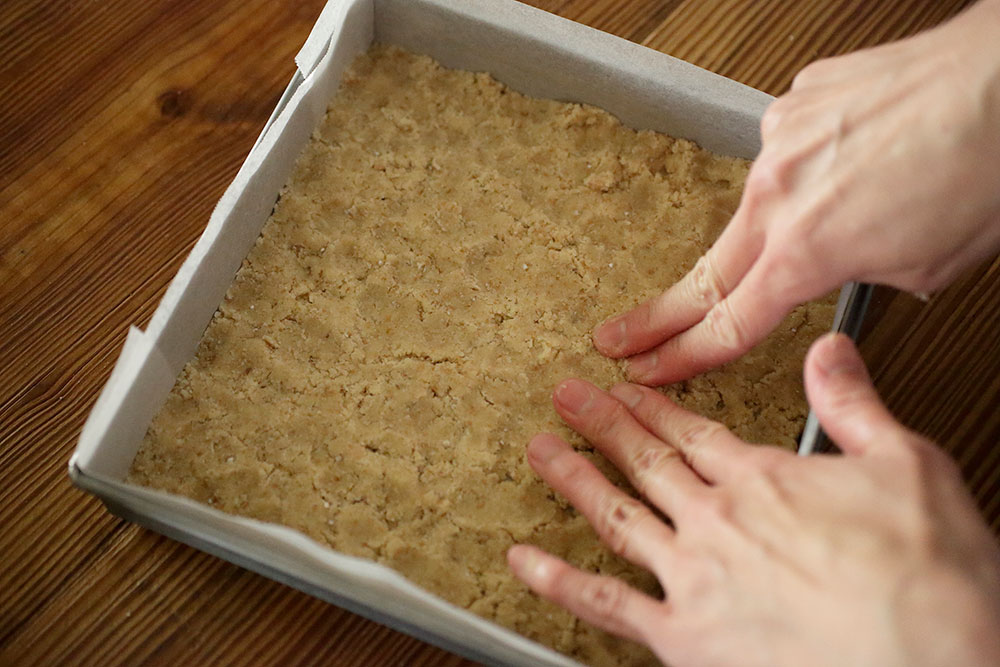 生地を型に入れ、指で押さえて底に広げる。フォークで穴をあける。160℃のコンベクションオーブンで約12分焼く。型に入れたまま室温で冷ます。 POINT:隙間なく敷き詰めるが、押さえすぎない。 [４]バター生地を作る