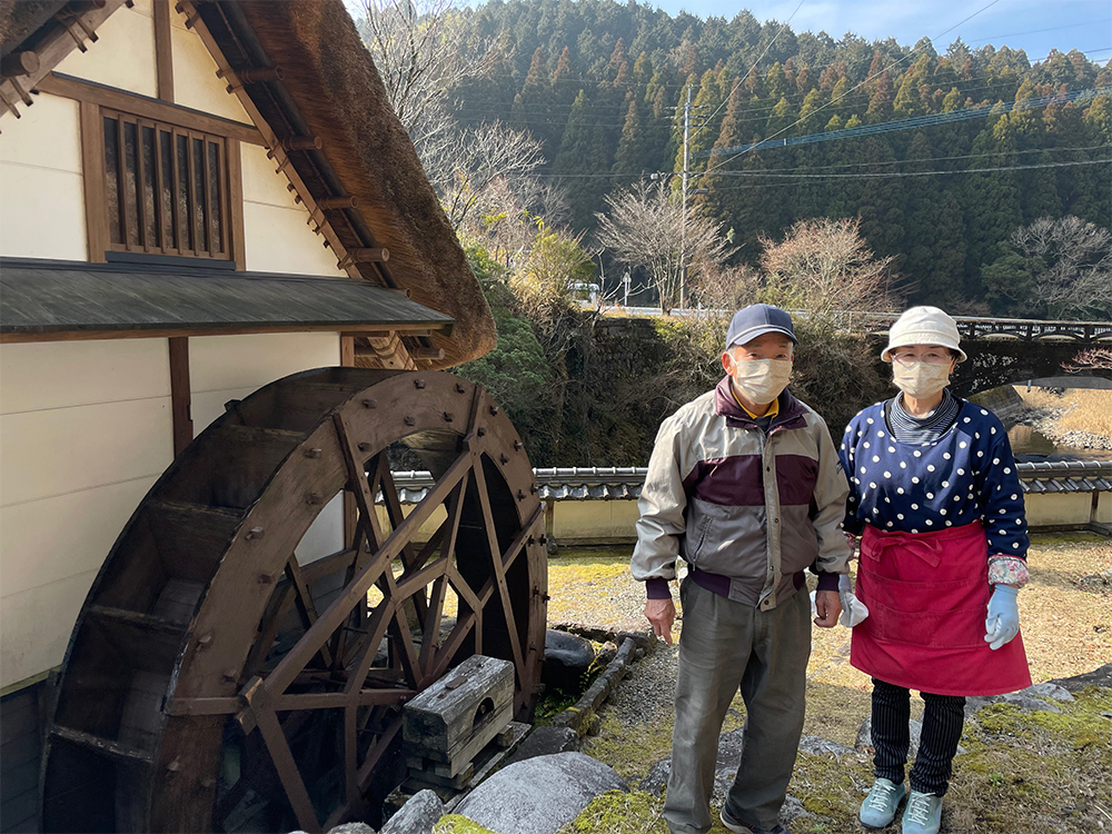 「成瀬水車」成瀬人司さん・百合子さんご夫妻。二人三脚で焼き米を作り続けている。昔はこの水車で精米をしていたが、現在は、家族の憩いの場として活躍している。