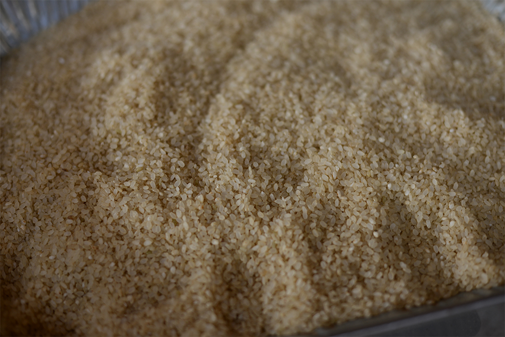 一番炒り後、精米した米。昔は、日陰などで生育が遅れた稲穂（八分ほどみのり、青味が残ったもの）を使っていたそうだ。