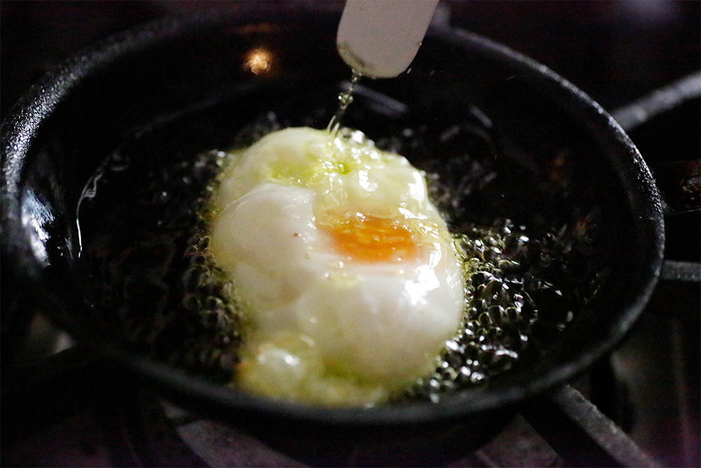 [５]表面にオイルをかける 卵が剥がれたら、パレットナイフで油を卵の表面にかけながら好みの加減まで火を通す。