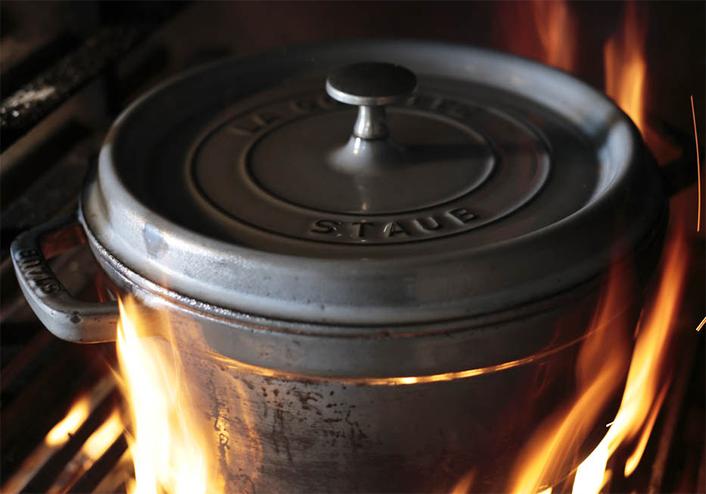 [８]提供前に再加熱する 提供の少し前になったら鍋に蓋をし、鍋ごと薪火で熱して香ばしく炙る。中火のガスコンロにかけてもOK。