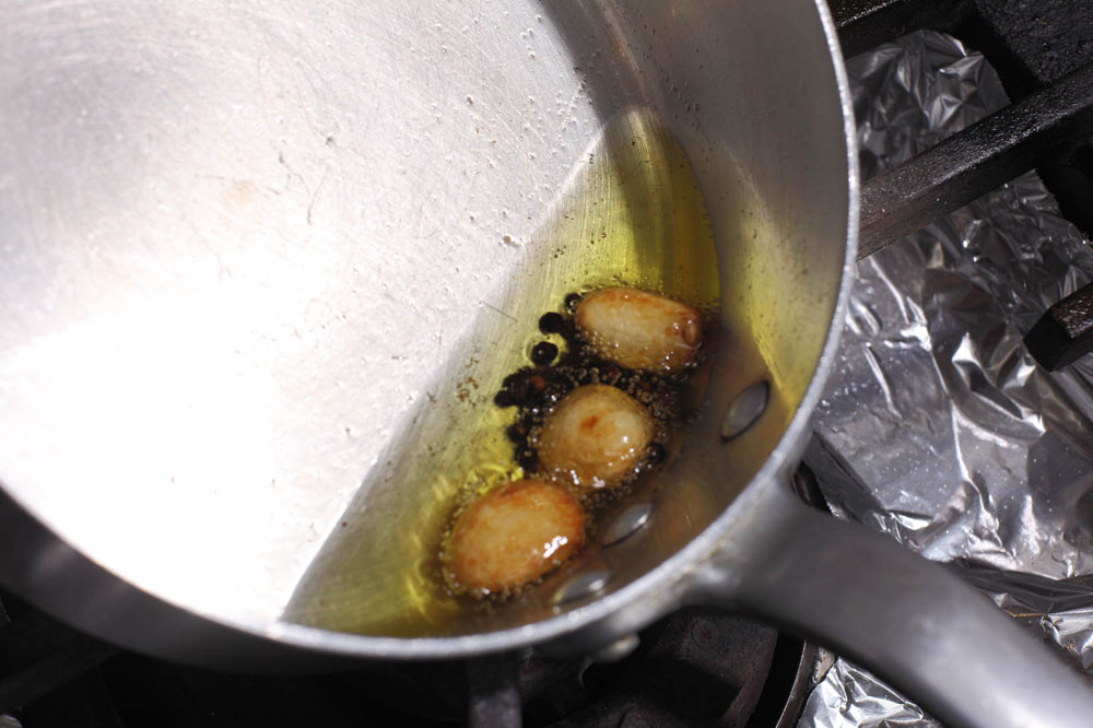 フライパンにオリーブ油、黒コショウ、ニンニクを入れて中火にかけ、ニンニクの香りが出て、軽く色づくまで熱する。 [３]牛スネ肉を加える