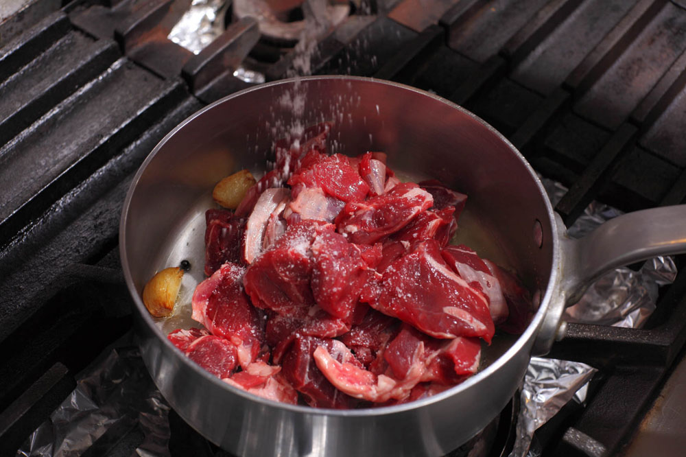 香りが出たら、牛スネ肉を加えて強火にし、塩をふる。 POINT:肉の水分が出ないように、塩は加熱後に加える。 [４]肉に焼き色をつける