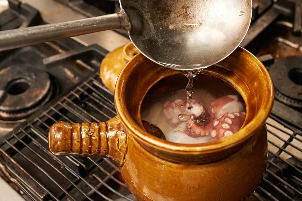 [３]土鍋に材料すべてを入れて、水を注ぎ入れ、火にかける。タコなど素材から旨味や塩分、甘味が出るので塩やだしは不要。 POINT：水で十分！　干しシイタケの戻し汁も使わない。 [４]蓋をして煮る