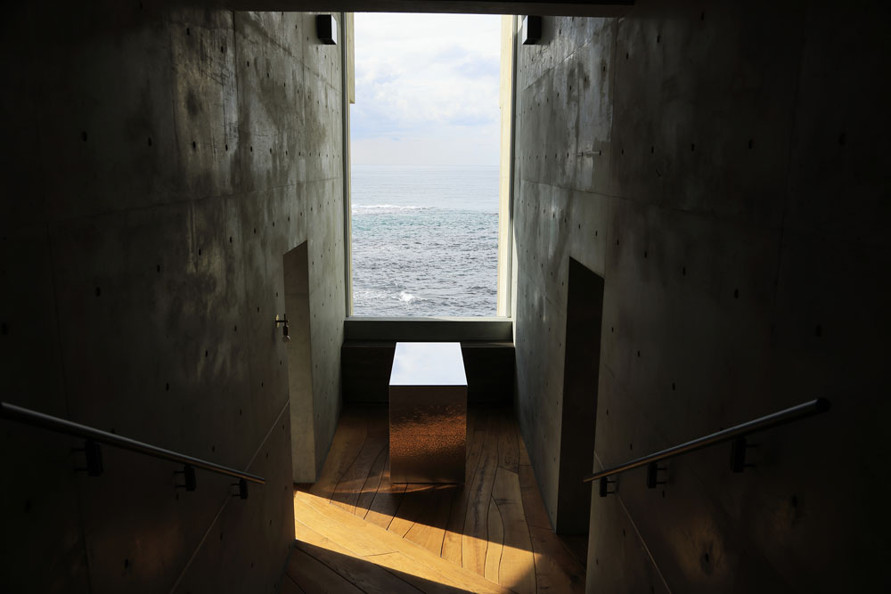 フロントから海を望む正面には、天井までの高さをもつ四角いフィックス窓。刻々と表情の変わる日本海の眺めが絵画のように切り取られ、シュールな造形美にはっとさせられる。