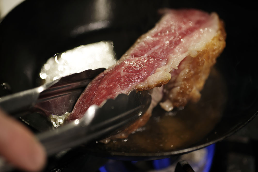 無角和種のトモサンカク（モモの一部）を塊で調理する。フライパンで表面を焼き付けてから、肉にストレスをかけないよう、サラマンダーでゆっくり火を入れていく。