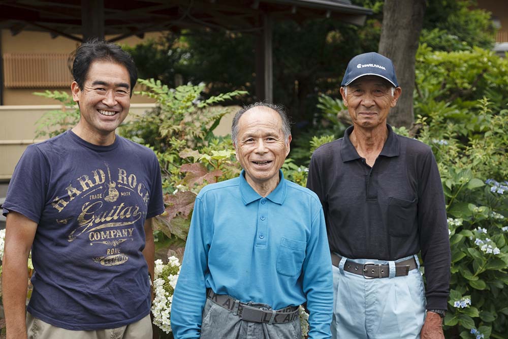 中央が田中久幸さん。一緒に採蜜を手伝う中村農園の中村安幸さん（右）と販売を担当する中村克之さん（左）。