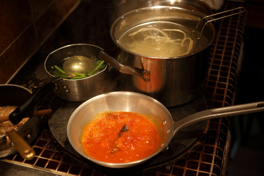 １枚の鉄板の上にいくつもの鍋を同居させて、熱を効率的に使う。