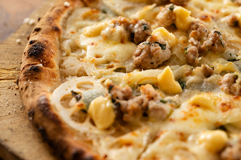 「茨城産マルタマ真レンコンと常陸の輝きのサルシッチャのピザ」。強く香らせたいバジルはあえて具の一番下に忍ばせる。