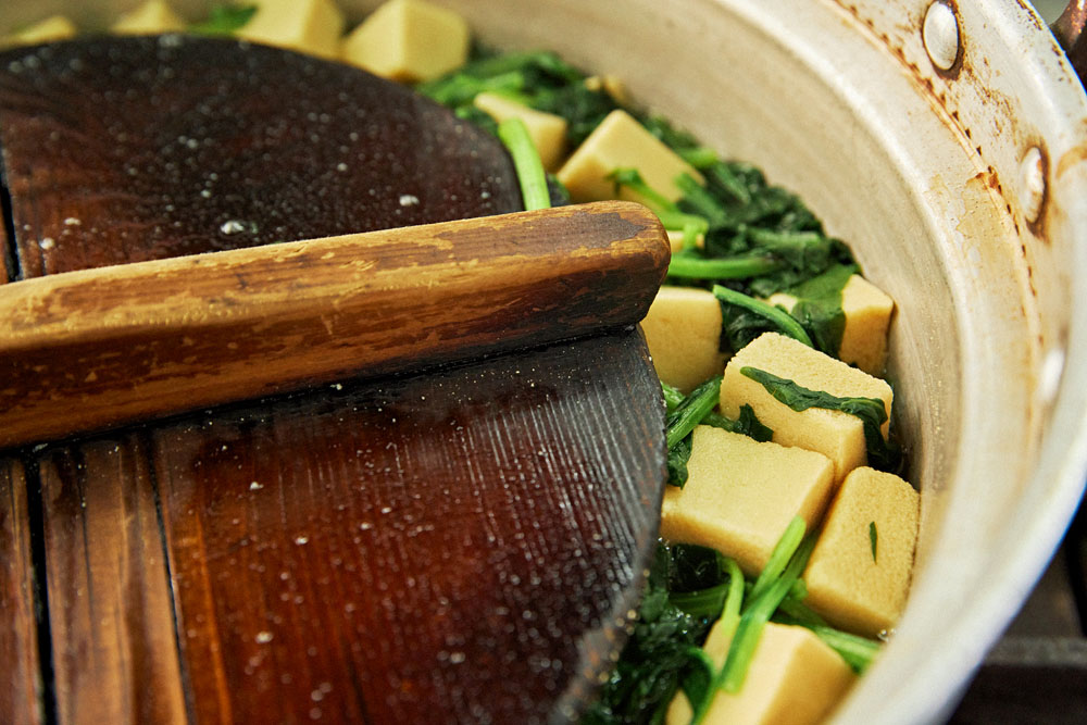 平皿に盛り込む高野豆腐を煮る。カボチャ、オクラ、ニンジンなど素材ごとに味付けする。