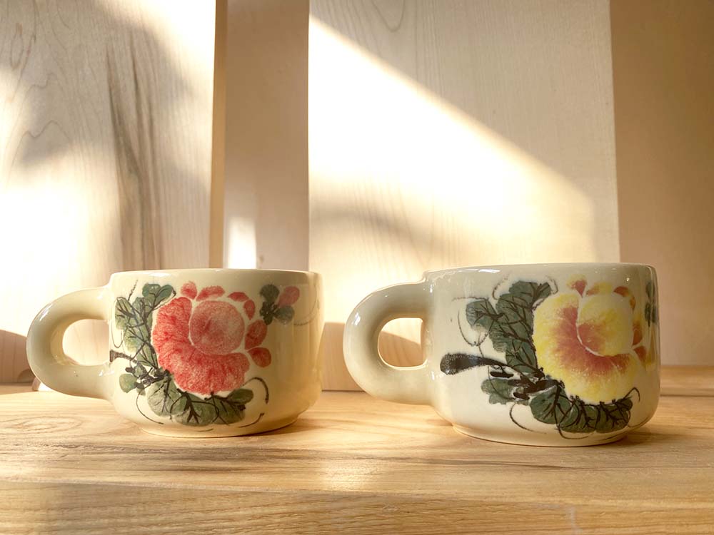 （写真）伝統的な芍薬の花を描いたマグカップ。赤色、黄色、ピンク色、青色など色使いも多様。絵柄は一つひとつ手描きのため、それぞれ異なる味わいをもつ。各149000ベトナムドン。