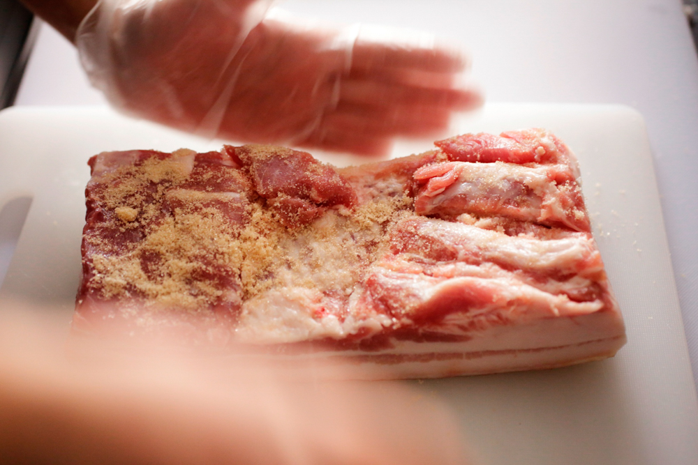 三温糖を肉の表、裏、側面にふりかけ、手で押さえてよく馴染ませる。
