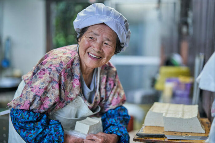 88 歳。「一日に作る豆腐は、36丁。大豆を煮る薪も、自分で割りよるよ」