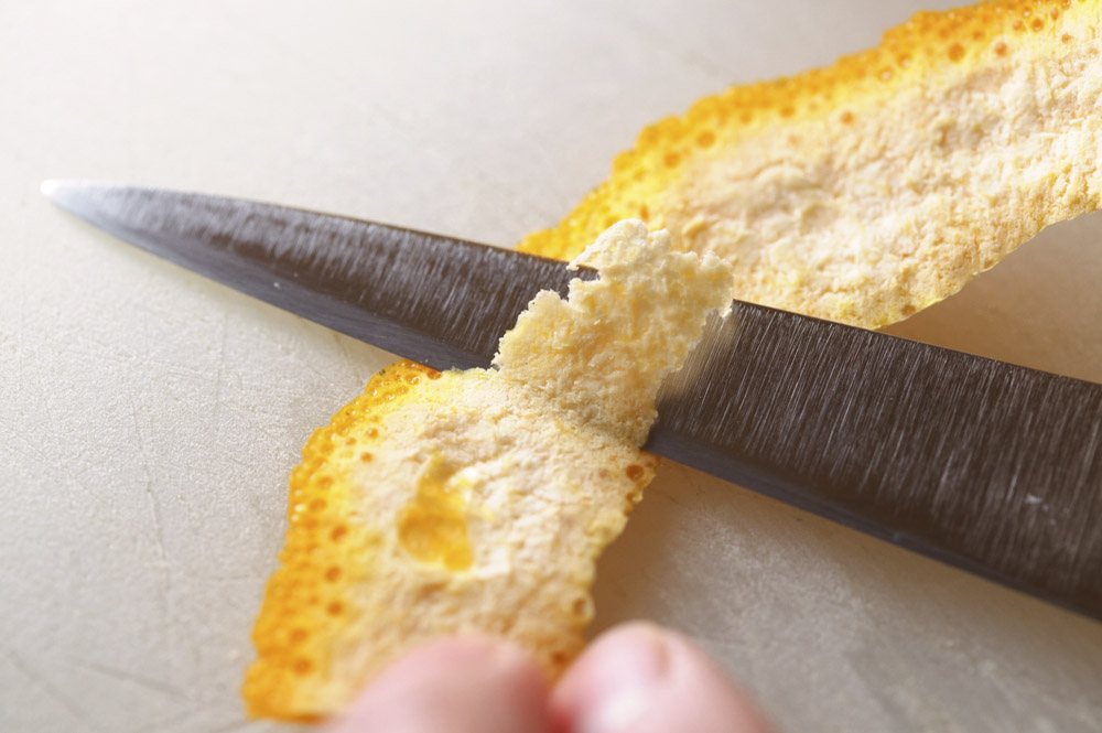 ポンカンはナイフで皮を剥き、苦味のもとになる裏の白いワタを削ぎ落とす。