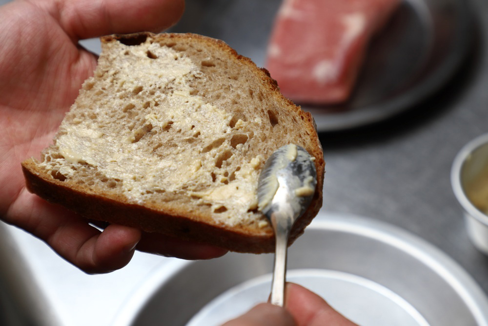 ［１］パンにバターと白腐乳を塗る